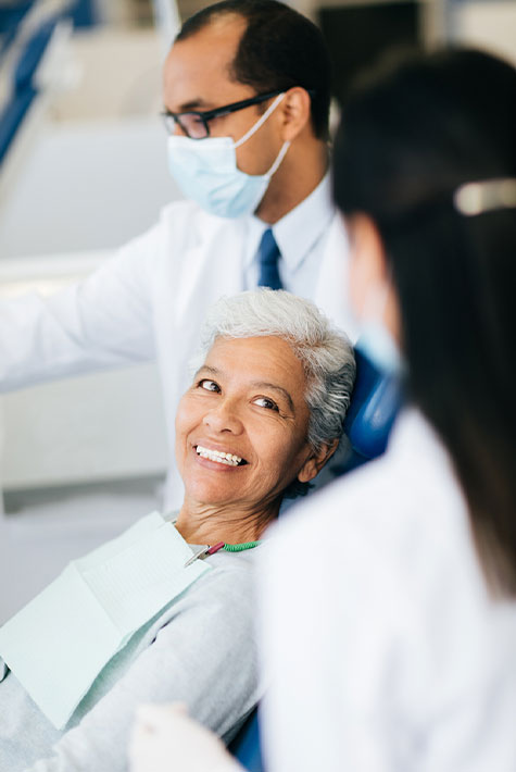 Dental health workers consulting cheerful senior patient stock photo