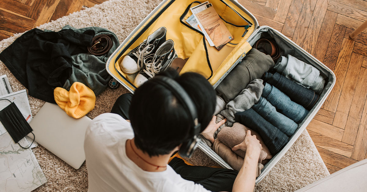 young adult packing a travel suitcase